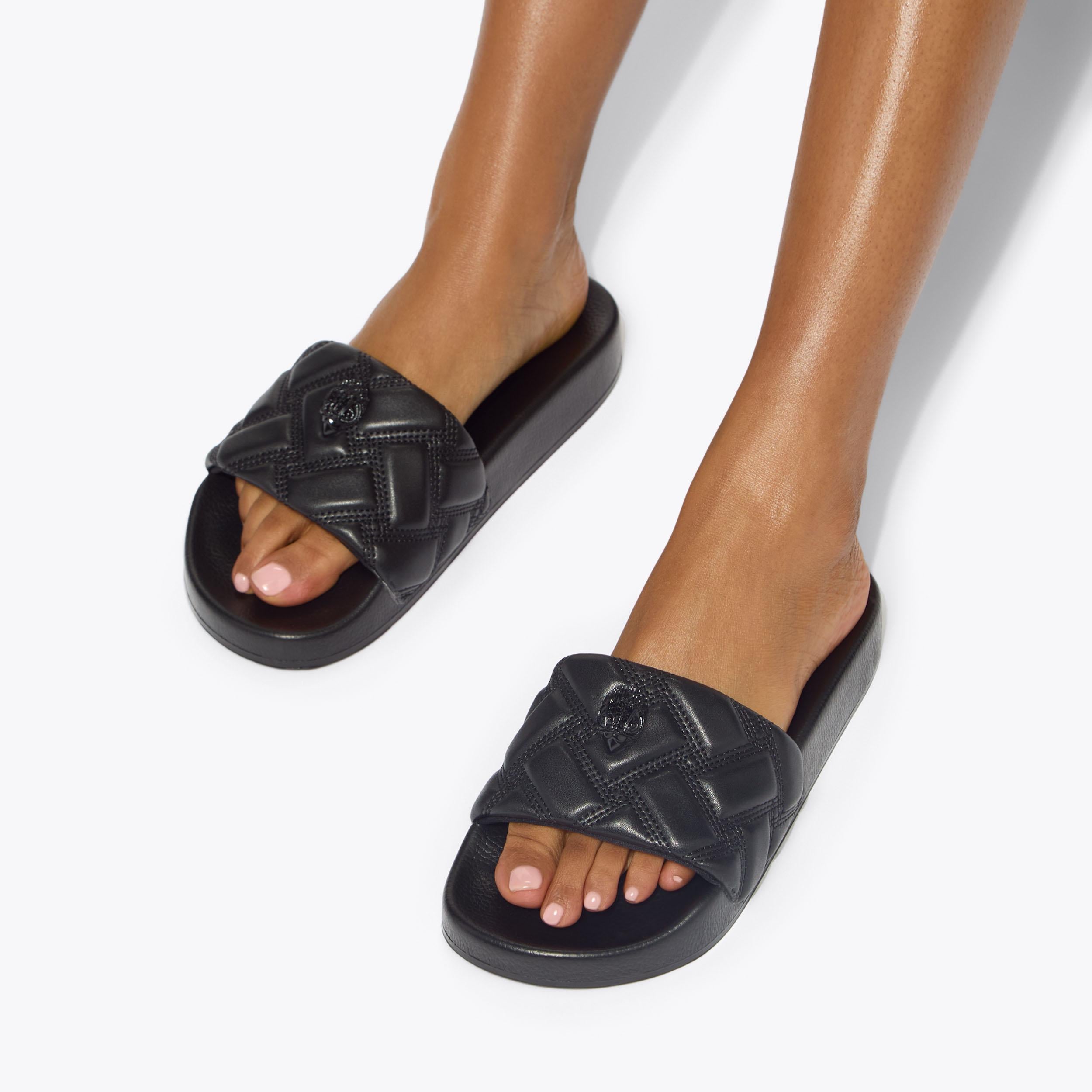 Meena Eagle — Black Quilted Slide, worn on foot